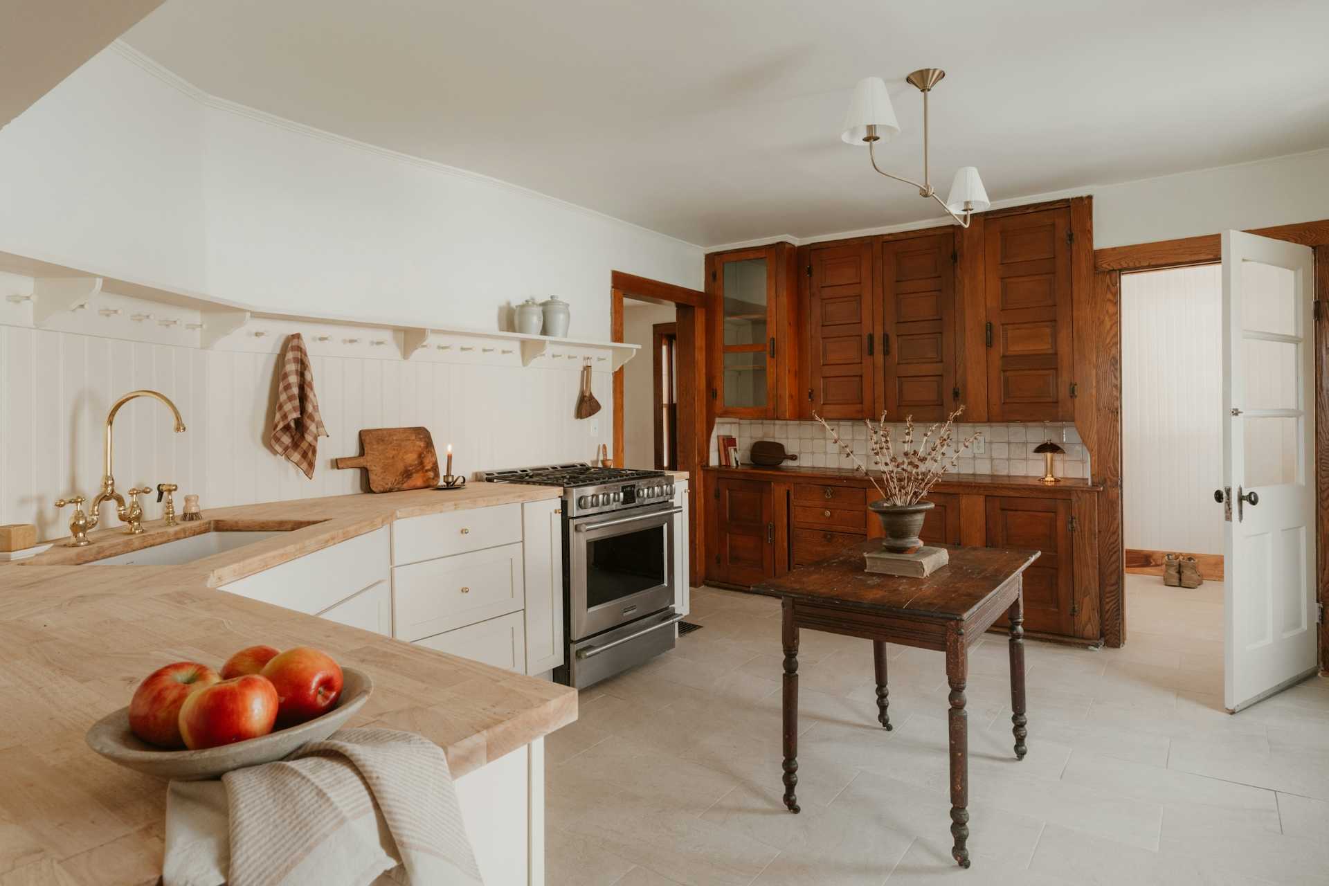 Warm wood cabinets and a small table in a traditionally detailed kitchen.